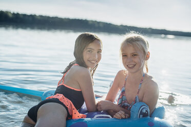 Porträt von zwei Mädchen mit Badespielzeug am See - MJF02187