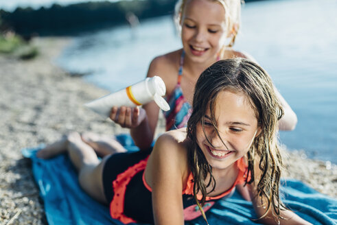 Porträt eines lachenden Mädchens am Strand mit ihrer Freundin - MJF02193