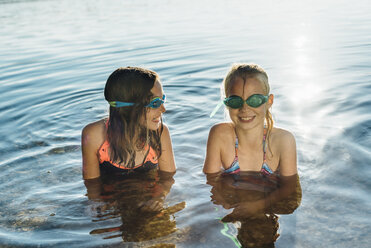 Zwei lächelnde Freunde mit Schwimmbrillen am Seeufer - MJF02197