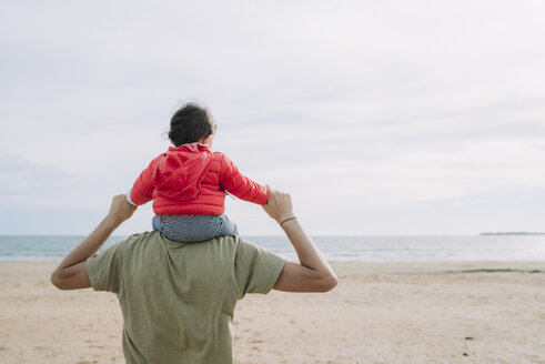 Rückenansicht eines Vaters, der seine kleine Tochter auf den Schultern am Strand trägt - GEMF01778