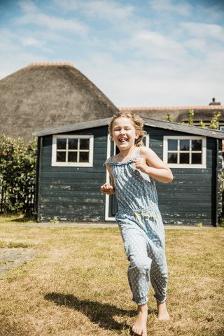 Happy girl running in garden stock photo