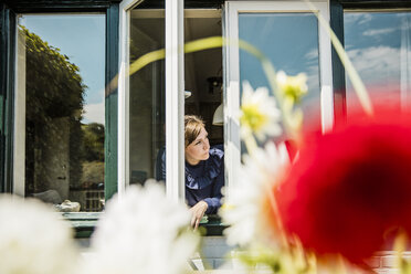 Frau schaut aus dem Fenster - MOEF00084