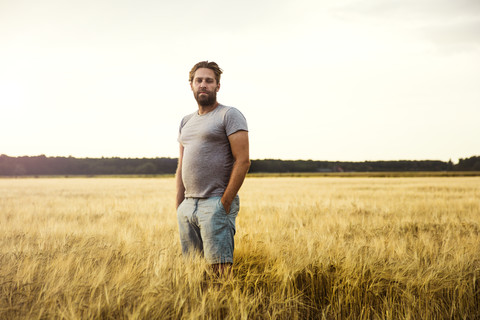Mann im Getreidefeld stehend, lizenzfreies Stockfoto