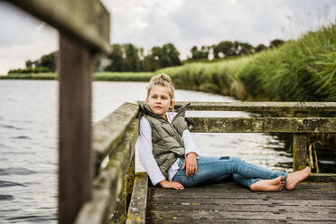 Mädchen sitzt auf einem Steg an einem See - MOEF00105