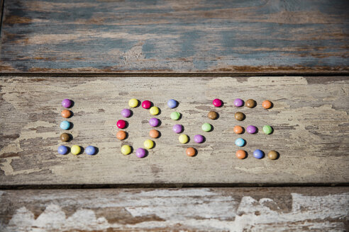 Schokoladentropfen, die auf einem Holztisch das Wort Liebe bilden - MOEF00110