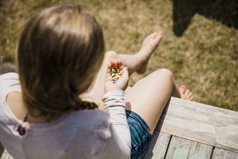 Mädchen hält Süßigkeiten in den Händen - MOEF00114