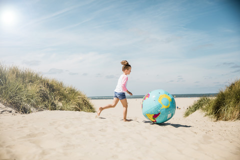 Mädchen spielt mit Globus am Strand, lizenzfreies Stockfoto