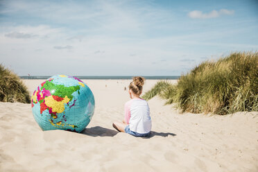Girl with globe on the beach - MOEF00124