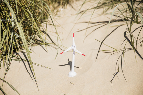 Modell einer Windkraftanlage am Strand in den Dünen, lizenzfreies Stockfoto