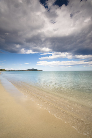 Italien, Sardinien, Strand unter bewölktem Himmel, lizenzfreies Stockfoto