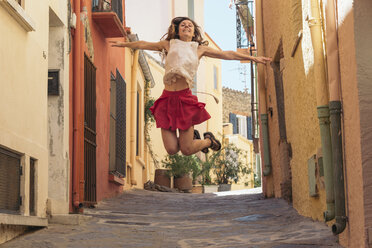 Frankreich, Collioure, junge Frau springt in eine Gasse - SKCF00314