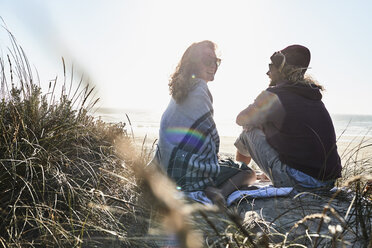 Portugal, Algarve, couple sitting on the beach at sunset - JRF00328