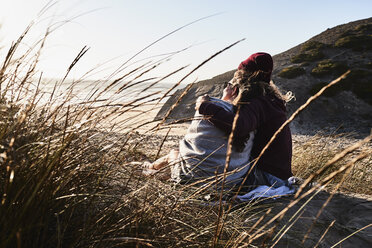 Portugal, Algarve, couple sitting on the beach at sunset - JRF00329