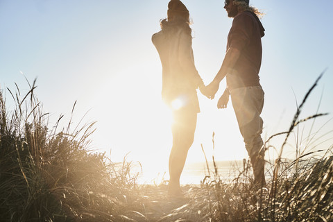 Portugal, Algarve, couple watching the sunset on the beach stock photo