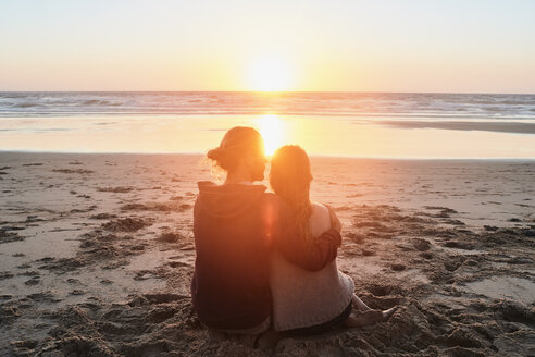 Portugal, Algarve, Paar am Strand sitzend bei Sonnenuntergang - JRF00346