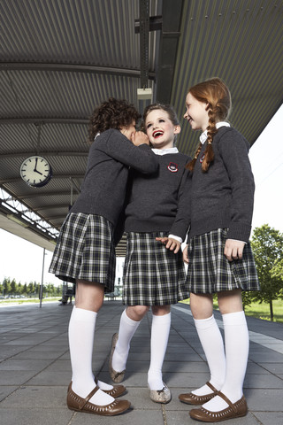 Drei Mädchen am Bahnsteig in Schuluniform, lizenzfreies Stockfoto