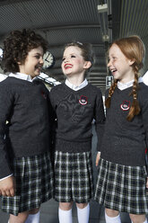 Three girls wearing school uniform talking on platform - FSF00946