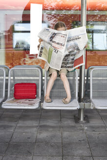 Kleines Mädchen sitzt am Bahnsteig und liest Zeitung - FSF00948