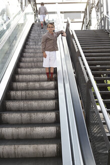Junge steht auf Rolltreppe, während sein Bruder weggeht - FSF00952