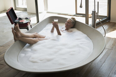 Man relaxing in bathtub with lighted candles arround stock photo