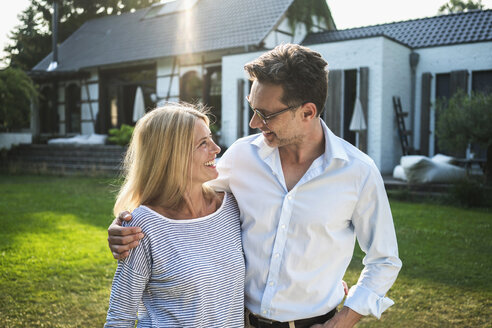 Happy couple in the garden of their country house - RIBF00696