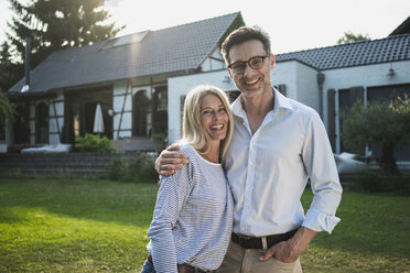 Happy couple in the garden of their country house - RIBF00698