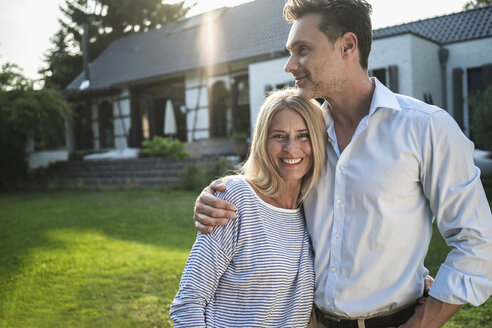 Happy couple in the garden of their country house - RIBF00700