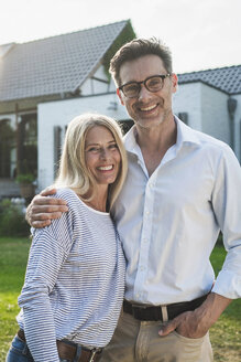 Glückliches Paar im Garten seines Landhauses - RIBF00707