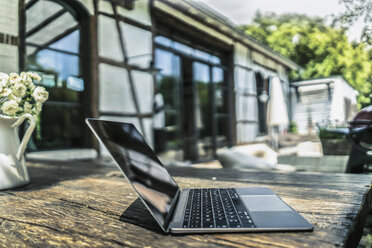 Laptop auf dem Tisch im Garten - RIBF00722