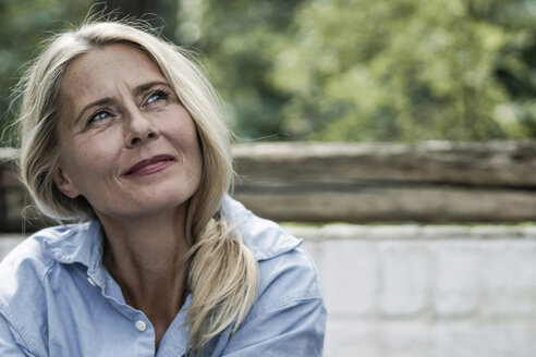 Mature woman sitting on terrace, thinking - RIBF00726