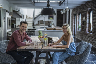 Happy couple siting in country house kitchen - RIBF00738