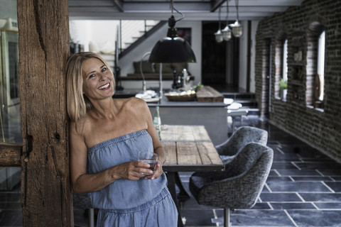 Woman standing in her comfortable country house, smiling stock photo