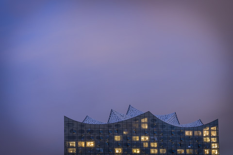 Deutschland, Hamburg, beleuchtete Elbphilharmonie in der Abenddämmerung, lizenzfreies Stockfoto