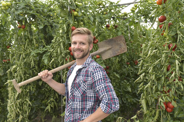 Porträt eines zufriedenen Gärtners im Gewächshaus mit Tomatenpflanzen - LYF00794