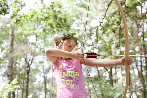 Mädchen schießt mit Pfeil und Bogen im Wald - MFRF00975