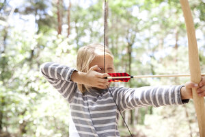 Mädchen schießt mit Pfeil und Bogen im Wald - MFRF00980