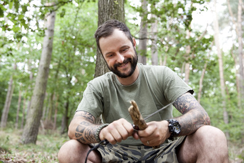 Smiling man carving in the forest stock photo