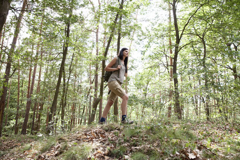 Junge Frau mit Rucksack bei einer Wanderung im Wald - MFRF01010