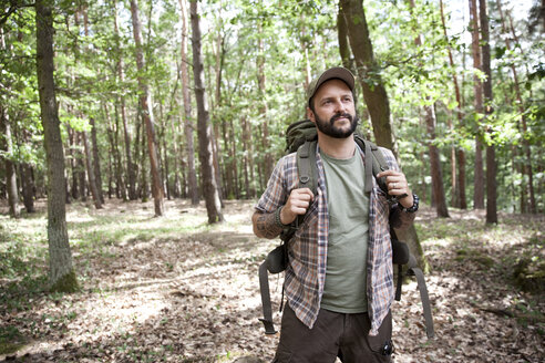 Ernster Mann mit Rucksack auf einer Wanderung im Wald - MFRF01017