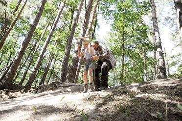 Vater mit Sohn auf Schaukel im Wald - MFRF01021