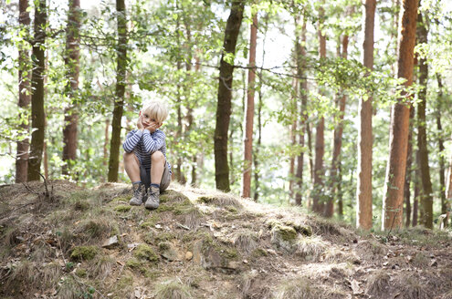 Junge im Wald auf einem Baumstumpf sitzend - MFRF01026