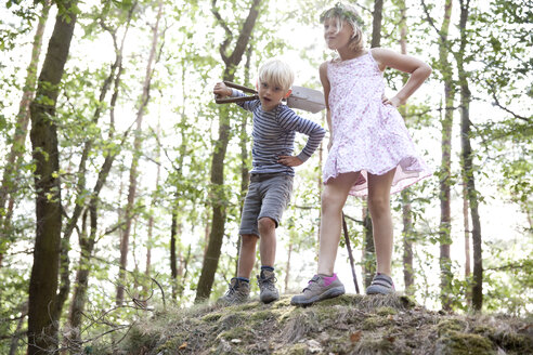 Junge und Mädchen stehen im Wald auf einem Hügel mit Spaten - MFRF01029
