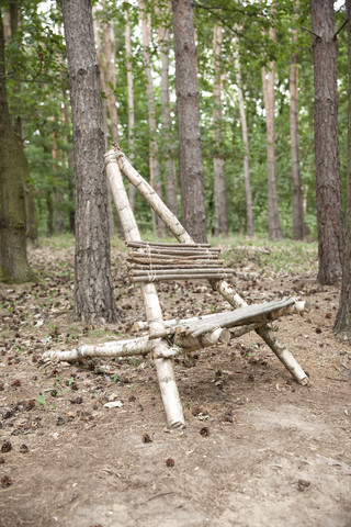 Selbstgebauter Holzstuhl im Wald, lizenzfreies Stockfoto