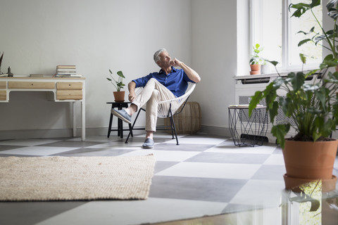 Älterer Mann sitzt zu Hause und denkt nach, lizenzfreies Stockfoto