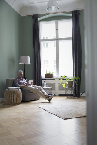 Mature man using tablet at home stock photo