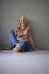 Portait of smiling mature woman at home sitting on the floor - RBF05888