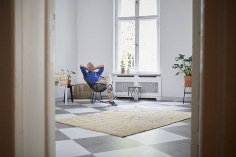 Relaxed mature man sitting at home stock photo