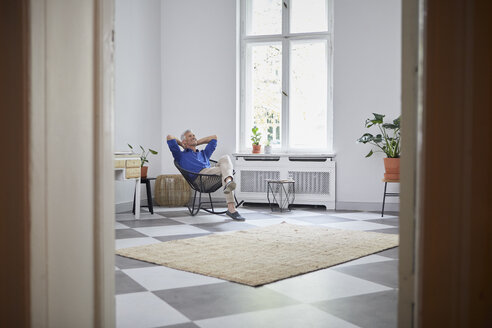 Entspannter reifer Mann sitzt zu Hause - RBF05895