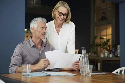 Mature couple with documents at home stock photo