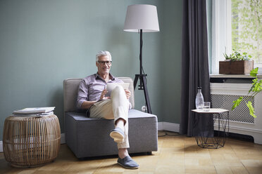 Portrait of smiling mature man using tablet at home - RBF05933